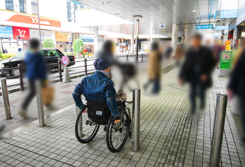 写真：車いす使用者が車両進入防止杭の間を移動する様子