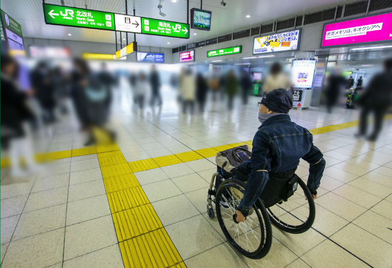 写真：車いす使用者が駅構内を移動する様子