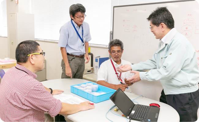 写真：平岡さんと3人の男性が打ち合わせる様子