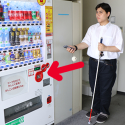 写真：視覚障がい者の編集部員が自販機を探している